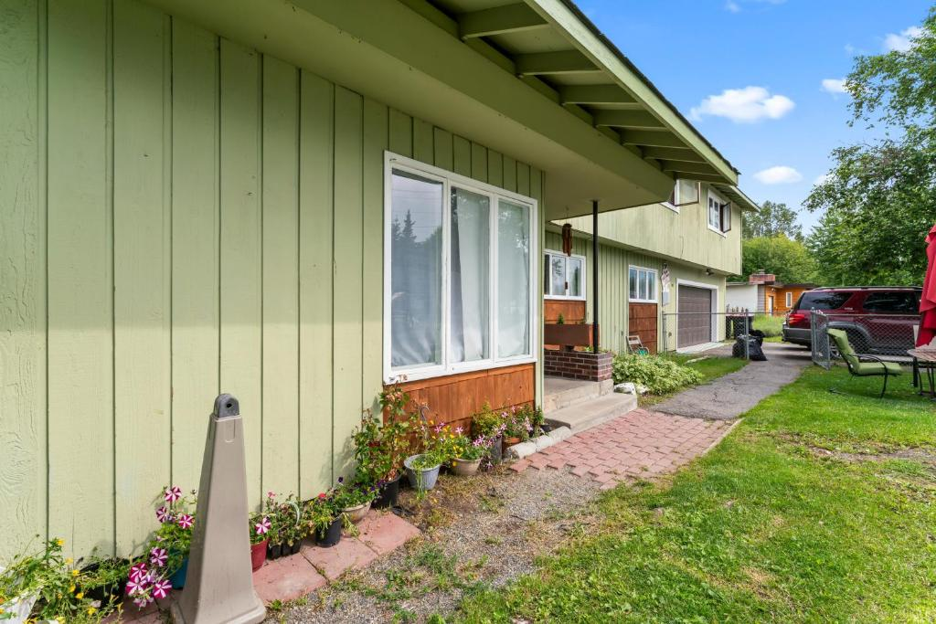 Green guesthouse exterior with covered porch, East 16th Avenue Anchorage