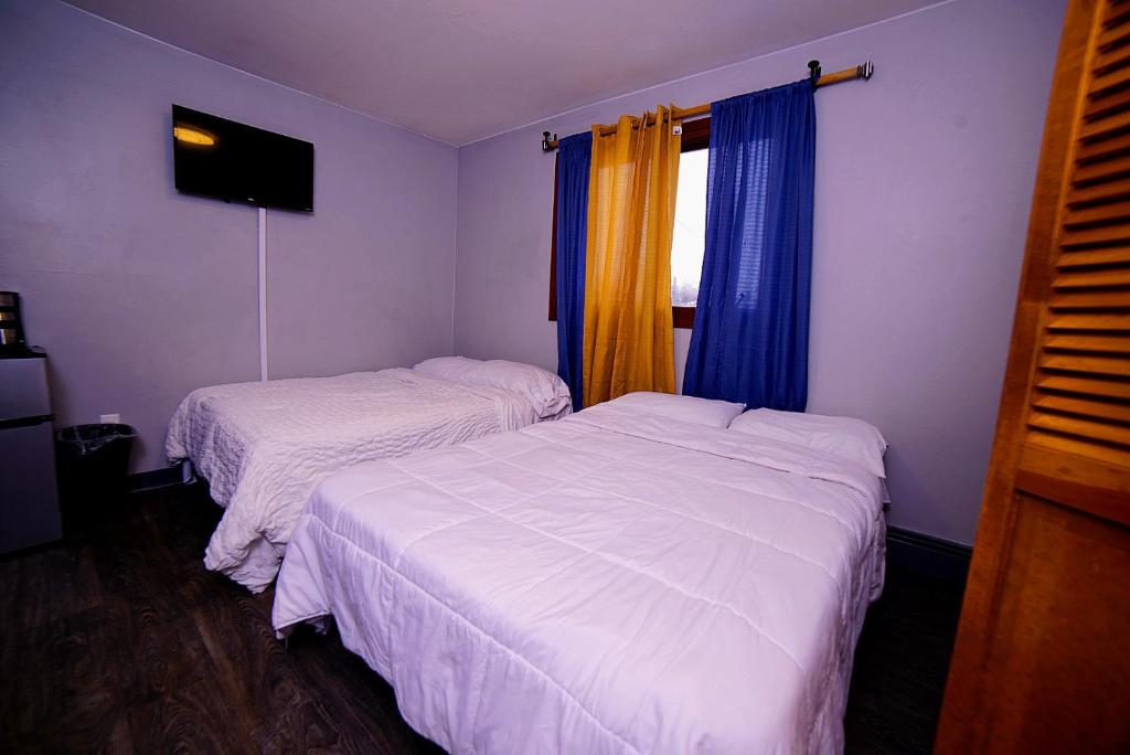 Two double beds with blue and yellow curtains, East 16th Avenue Anchorage
