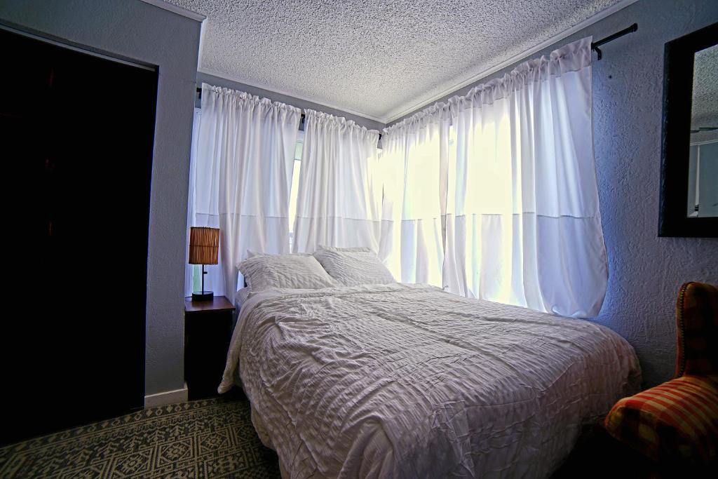 Bedroom with plaid armchair and mirror, ShaligoHomes Queen Suite, Anchorage AK