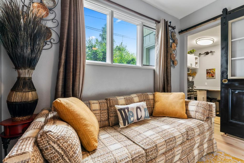 Living area with plaid sofa and Welcome pillow, Stylish Studio Suite, Anchorage